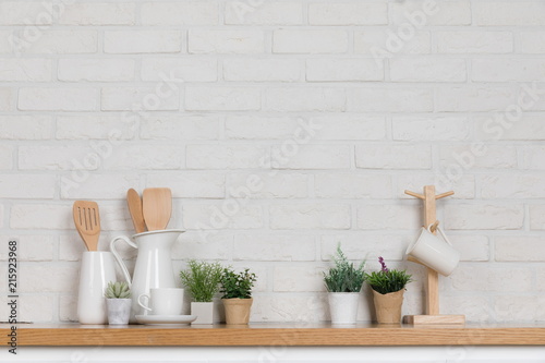 Kitchen utensils and dishware on wooden shelf. Kitchen interior background.Text space.