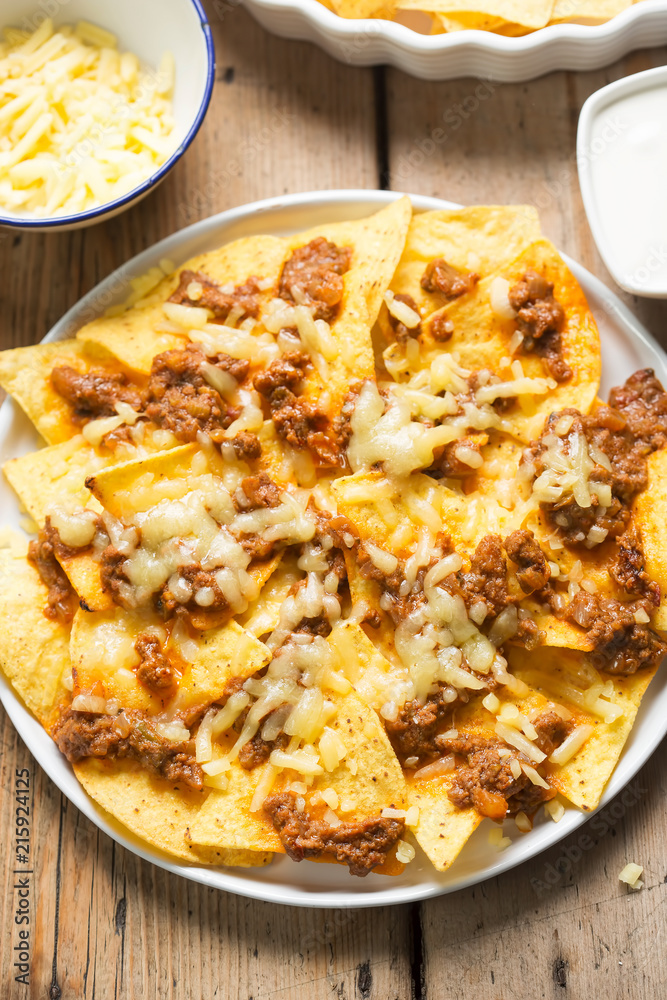 Chilli beef nachos with sour cream & grated cheese Chilli beef nachos with sour cream & grated cheese
