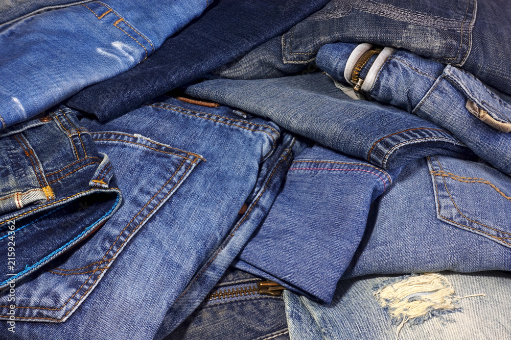 A pile of different jeans trousers as background.
