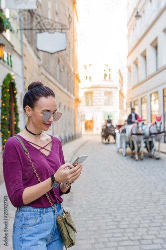 Canvas Print Woman talk by her smartphone in city