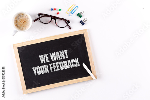 WE WANT YOUR FEEDBACK phrase on Chalkboard with Coffee Cup, view from above