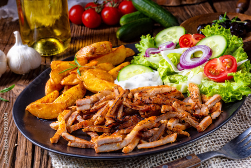 Rustic gyros plate it green salad and potato wedges photo