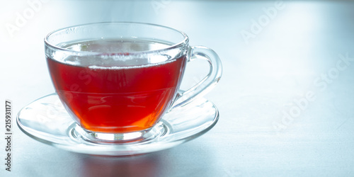 A glass mug with hot black tea