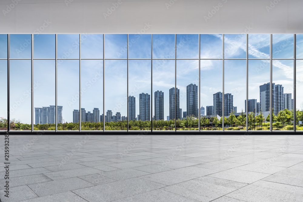 Fototapeta premium Panoramiczna linia horyzontu i nowożytni biznesowi budynki biurowi z pustą drogą, pusta betonowa podłoga