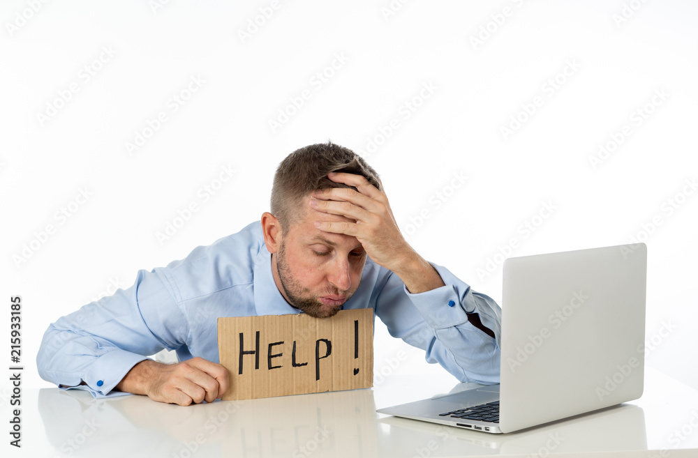 Young attractive caucasian businessmen showing help sign desperate suffering stress at work while sitting at office laptop computer desk in business overwork male feeling stressed and overwhelmed. Young attractive caucasian businessmen showing help sign desperate suffering stress at work while sitting at office laptop computer desk in business overwork male feeling stressed and overwhelmed.