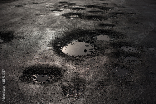 pothole in the road looking like alien craters photo