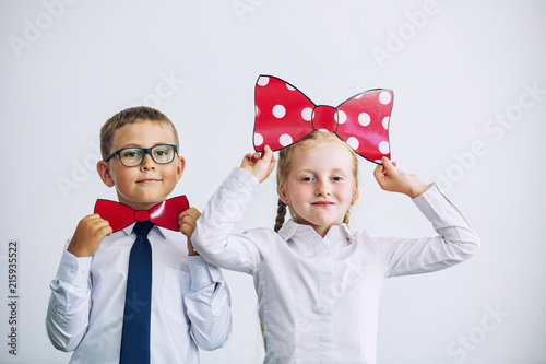 Beautiful kids boy and girl with butterfly butterflies together in school uniform happy on white background