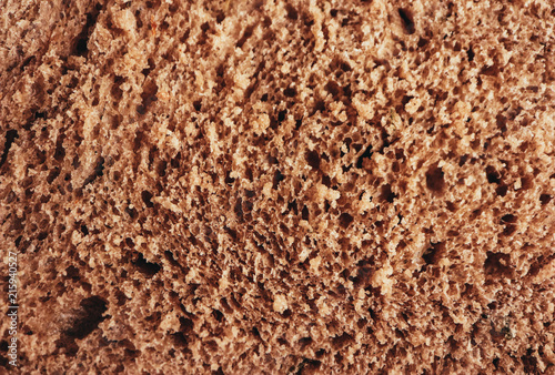 A piece of handmade freshly baked rye bread, texture background, closeup.