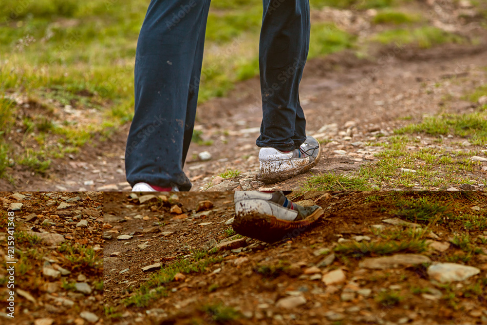Close-up of a foot of a young tourist man in white sneakers walking on a dirt road in the mountains