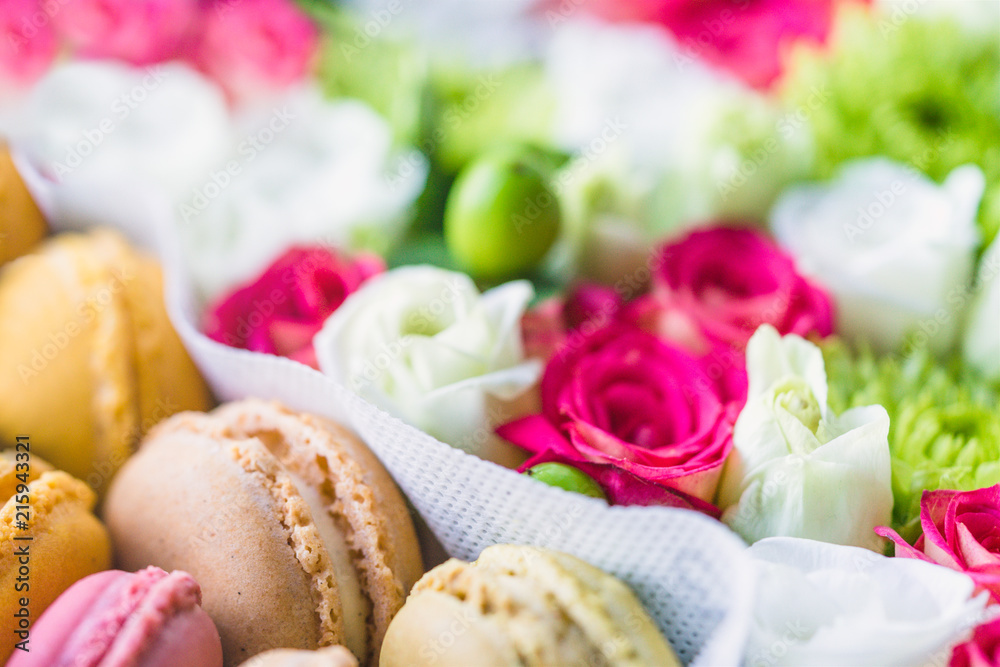 Macarons and flowers background, closeup