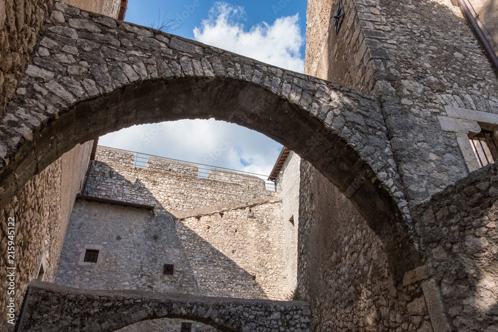 Low angle view of stone castle arches and walls from an inside courtyard.