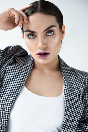 attractive girl with makeup posing in vintage jacket, isolated on grey © LIGHTFIELD STUDIOS
