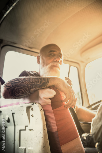 Portrait of a senior hipster inside their vintage van 