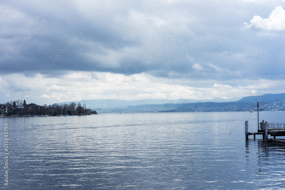 pier at lake zurich with clouds and blue water