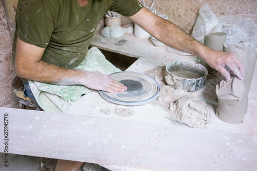 Ceramic dishes in working process. Creating ceramic pieces. Tradicional ceramic factory in spain. man working with traditional potter's wheel