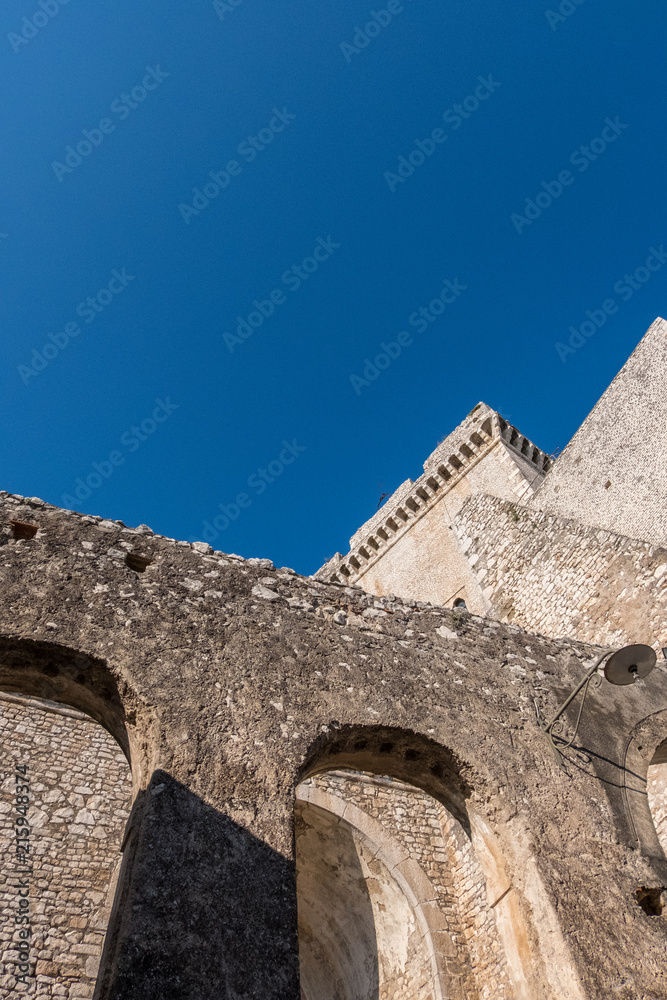 Vertical photo of medieval castle construction with blue sky background.