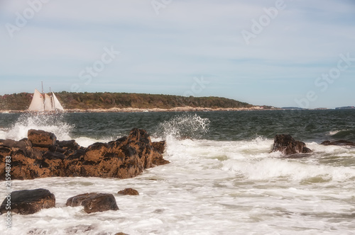 Coast of the Atlantic Ocean.  A sailboat floating among the waves. Maine. Portland.
