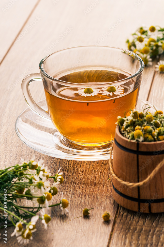 Glass cup of green tea with white chamomile flowers Glass cup of green tea with white chamomile flowers