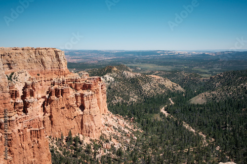 Red cliffs and view down forested canyon in Utah, USA.