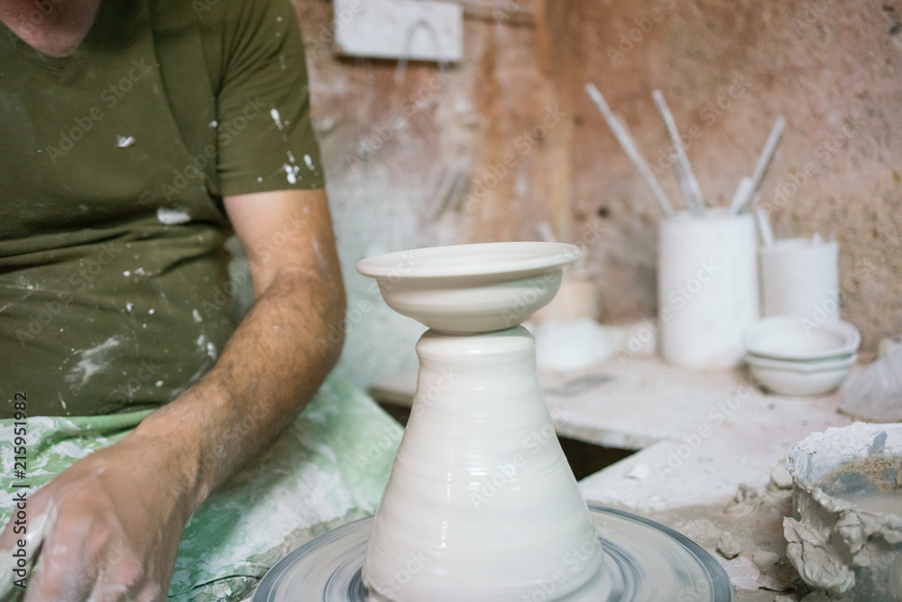 Ceramic dishes in working process. Creating ceramic pieces. Tradicional ceramic factory in spain. man working with traditional potter's wheel