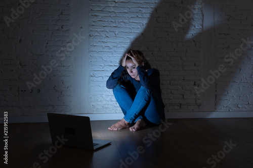 Sad and scared female Young woman with computer laptop suffering cyberbullying and harassment being online abused by stalker or gossip feeling desperate and humiliated in cyber bullying concept.