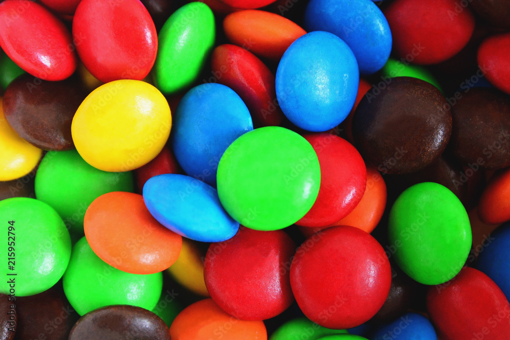 Background of colorful button-shaped candies coated chocolate sweets on white background. Background of colorful button-shaped candies coated chocolate sweets on white background.