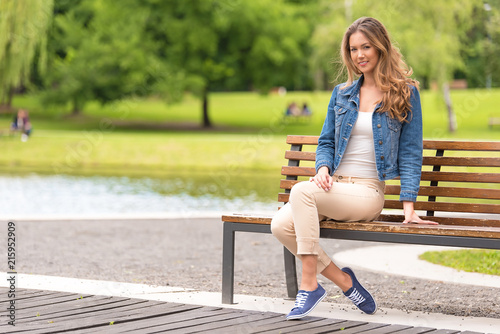 Принти на полотні Young woman sitting on bench in park