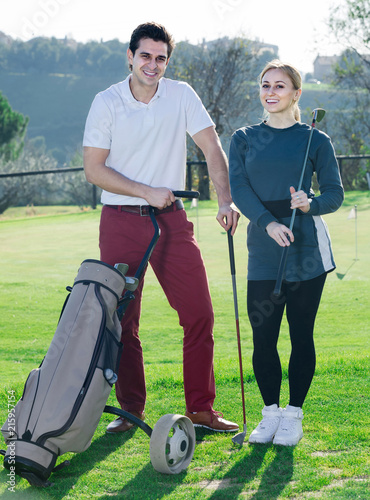 Male and female golfers ready for team play at golf course