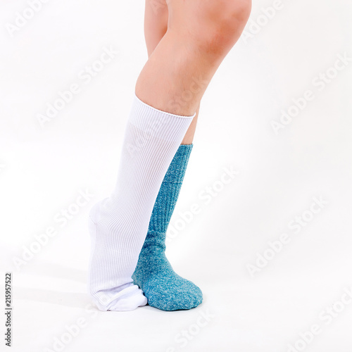White and blue cotton socks on beautiful woman's feet. Isolated on white background. Studio lighting