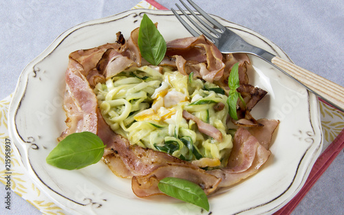 Scrambled eggs with zucchini, carbonara sauce and bacon photo