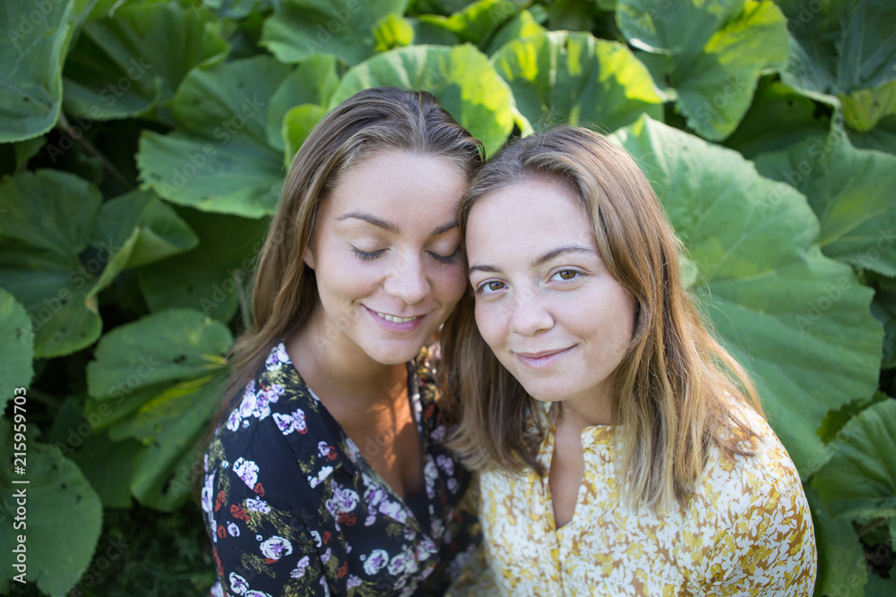 Pure love.Two beautiful sisters with summer clothes in park . Pure love.Two beautiful sisters with summer clothes in park .