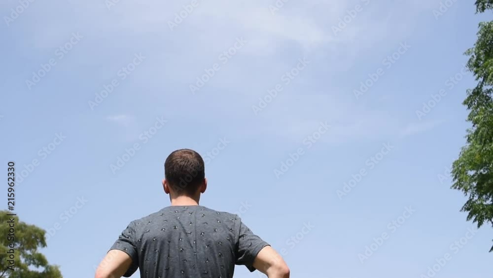 Hombre con camiseta azul de espaldas bajo dielo azul despejado al aire libre en la naturaleza. Hombre con camiseta azul de espaldas bajo dielo azul despejado al aire libre en la naturaleza.
