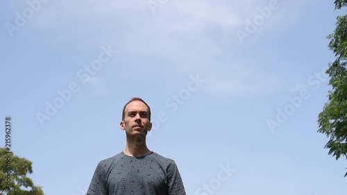 Hombre de frente bajo un cielo azul despejado al aire libre en la naturaleza.