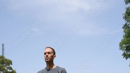 Hombre de frente bajo un cielo azul despejado al aire libre en la naturaleza.
