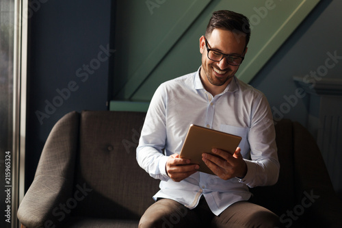 Businessman wearing glasses holding tablet