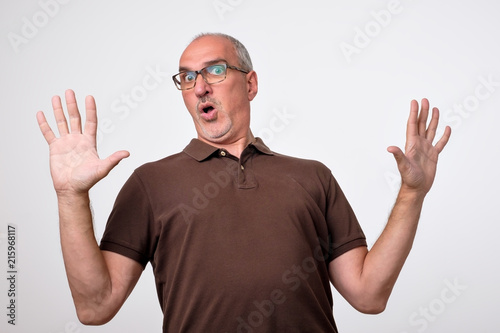 Man body language. I did not do it concept. Mature italian handsome man raising hands up. It is not my mistake