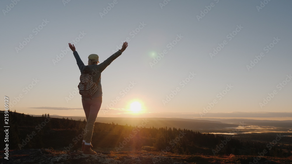 An active woman comes to the top of the mountain with an impressive view downstairs. Traveling in Norway