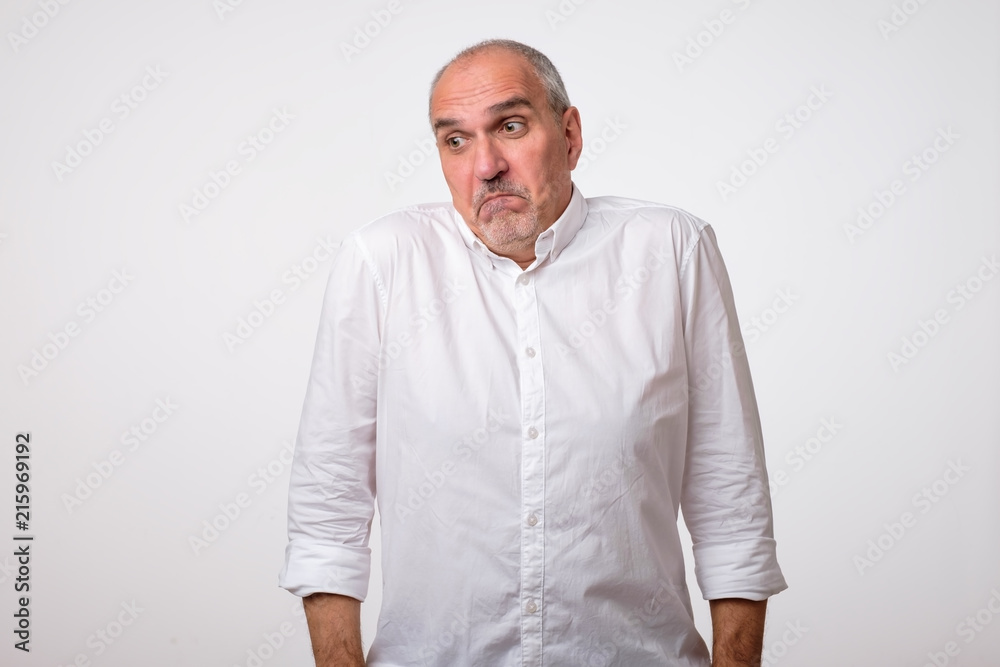 Mature man shrugging shoulders in confusion. Hispanic handsome guy gesturing and looking at camera. Do not know concept Mature man shrugging shoulders in confusion. Hispanic handsome guy gesturing and looking at camera. Do not know concept