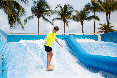 Teenager boy surfing in beach wave simulator © famveldman