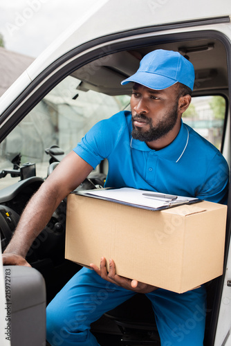 african american delivery man going out from car with box © LIGHTFIELD STUDIOS