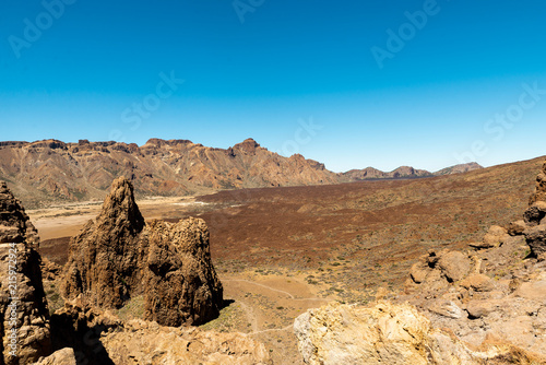 View of landscape of Teide National Park on Tenerife, Canarias islands, Spain. Yellow and black sand and distance view of mountains roads and volcano. © Yuliia