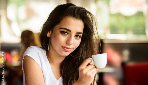 Girl enjoy aromatic coffee drink. Girl attractive gorgeous brunette middle eastern appearance drinks coffee close up. Woman smiling face make up holds coffee cup. Coffee worldwide traditional drink