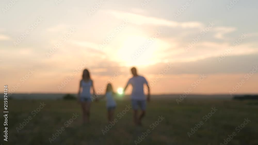 Silhouette, happy child with mother and father, family at sunset, summertime. We are happy family. The concept of the family.