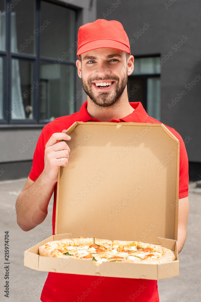 smiling caucasian delivery man holding box with pizza smiling caucasian delivery man holding box with pizza