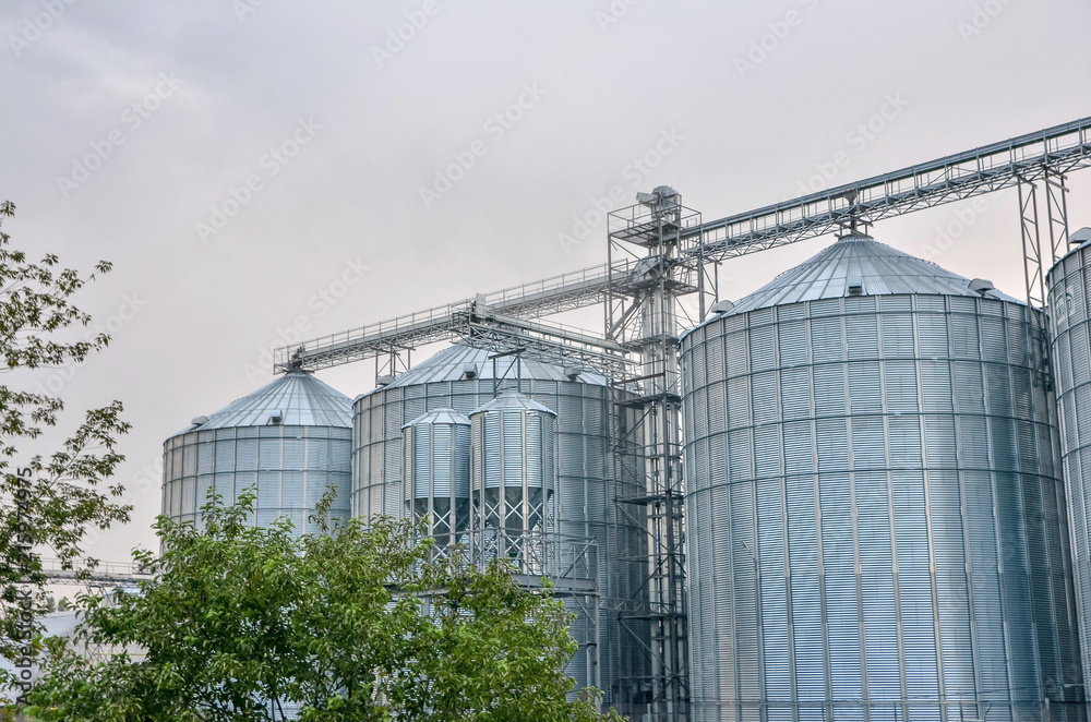 Complex of grain elevators for storing grain at dusk time.