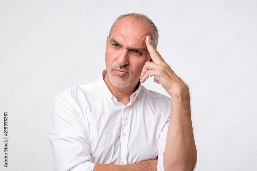 mature caucasian man thinking pensive looking up studio portrait. He is trying to make a decision or right choose mature caucasian man thinking pensive looking up studio portrait. He is trying to make a decision or right choose