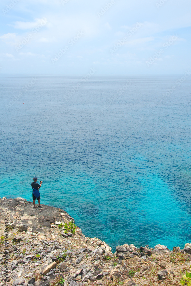 Man standing on a cliff in front Sea