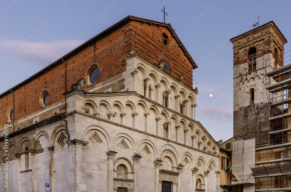 Beautiful view of the ancient Church of Santa Maria Forisportam at sunset with the moon in the background, Lucca, Tuscany, Italy
