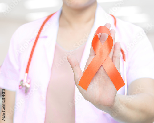 Doctor with orange ribbon awareness in hand as stop sign for ADHD,COPD,Cultural Diversity,Kidney Cancer - Renal Cell Carcinoma,Leukemia, Lupus,Malnutrition,Self Injury photo