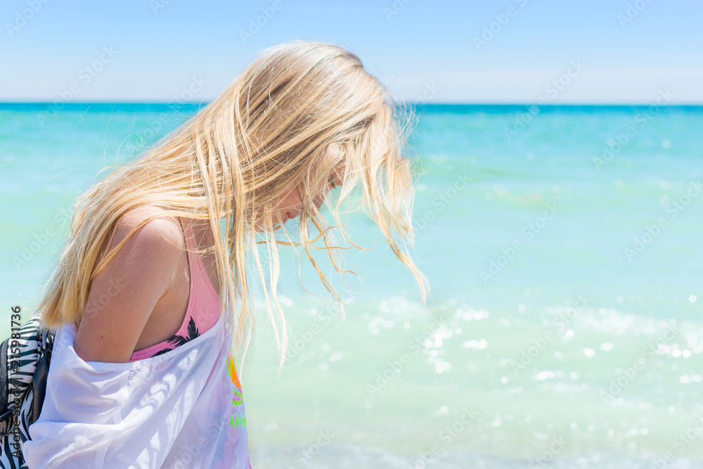 Naklejka premium Girl teenager in profile with disheveled hair on the sea.